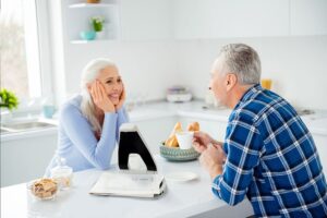 Billede af Hark Reader Læsemaskinen placeret på et bord i et køkken ved siden af to personer