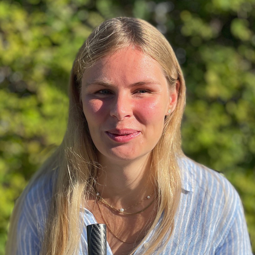 Billede af Sofie Brix Monggaard som står i solen og med en grøn hæk som baggrund.