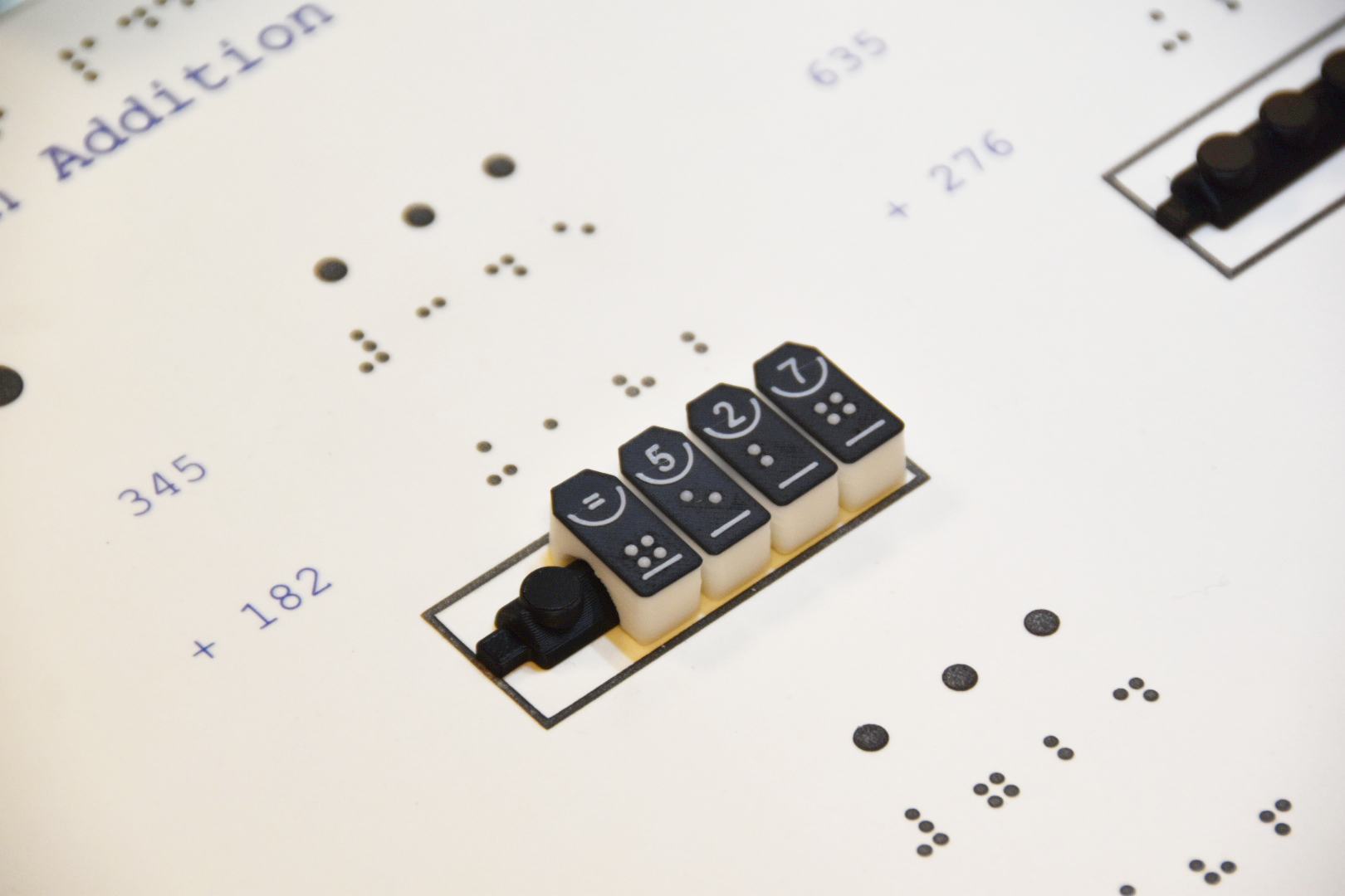 Billede af Tactonom Reader Flex Matematik Punktskriftbrikker som benyttes til at løse et regnestykke